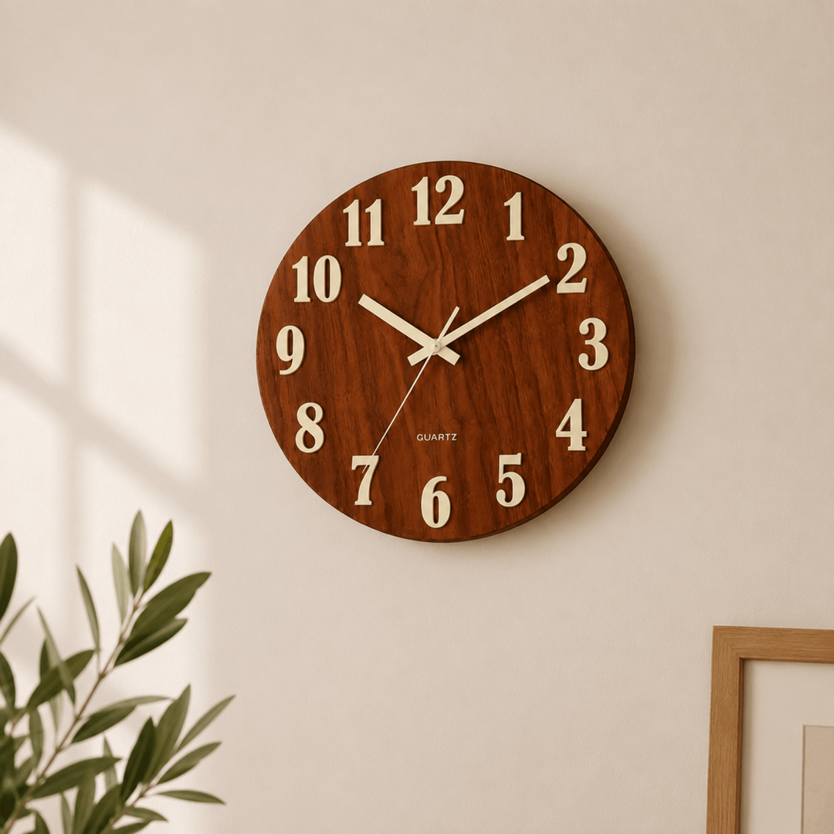 Ronde houten wandklok met warme bruine houtlook en crème cijfers aan gebroken witte muur