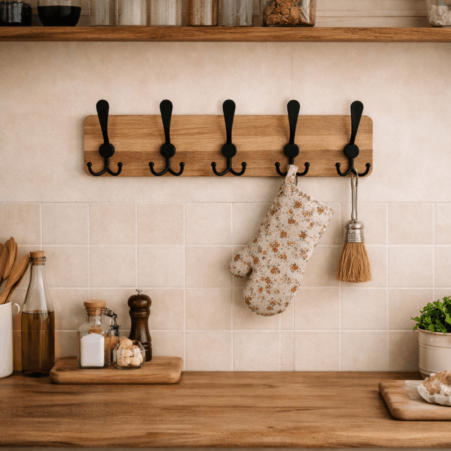 Houten wandkapstok met vijf dubbele zwarte haken, ideaal voor het ophangen van keukengerei zoals ovenwanten en accessoires aan de muur.