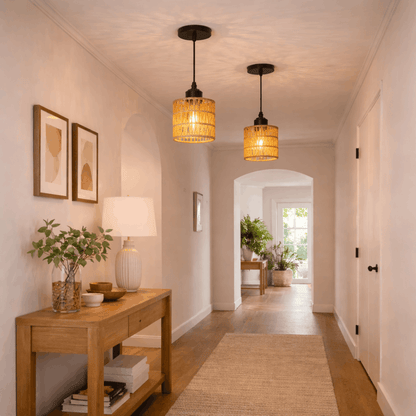 Twee rotan hanglampen met warm licht in een lange hal, zorgen voor een sfeervolle en natuurlijke uitstraling in het interieur.