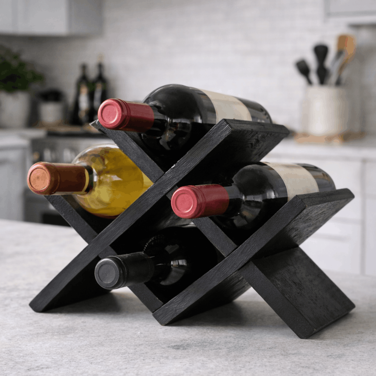 Modern zwart houten wijnrek met kruislings ontwerp voor het horizontaal bewaren van vier wijnflessen op het aanrecht in de keuken.