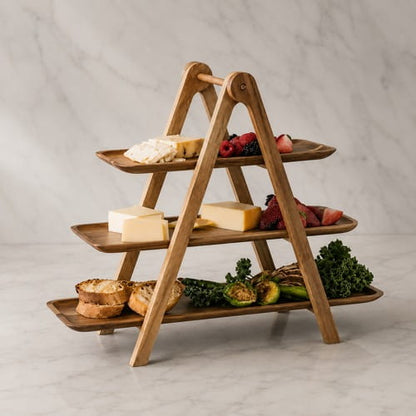Houten borrelplank etagère met kaas, groenten, brood en fruit op een marmeren ondergrond.