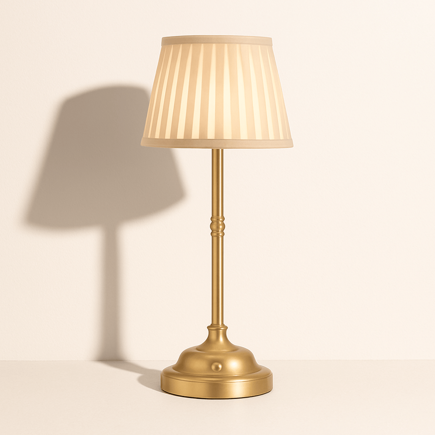 Elegante messing tafellamp met beige plissé kap, geeft warm licht en voegt klassieke charme toe aan elke ruimte.