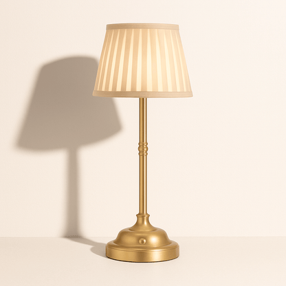 Elegante messing tafellamp met beige plissé kap, geeft warm licht en voegt klassieke charme toe aan elke ruimte.