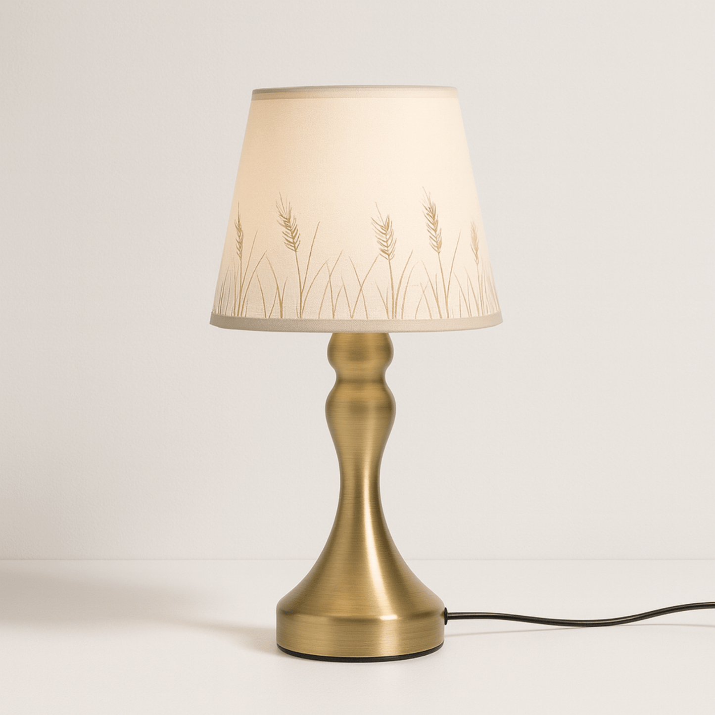 Messing tafellamp met beige kap en subtiel graanmotenpatroon, perfect voor een landelijke en warme sfeer.