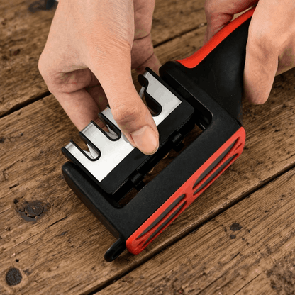 Handmatige messenslijper met uitneembare slijpelementen en ergonomische handgreep, getoond tijdens gebruik op een houten oppervlak.