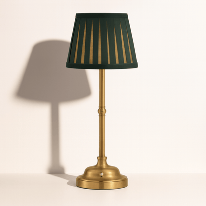 Messing tafellamp met donkergroene plissé kap en elegante voet, ideaal voor een klassiek en sfeervol interieur.