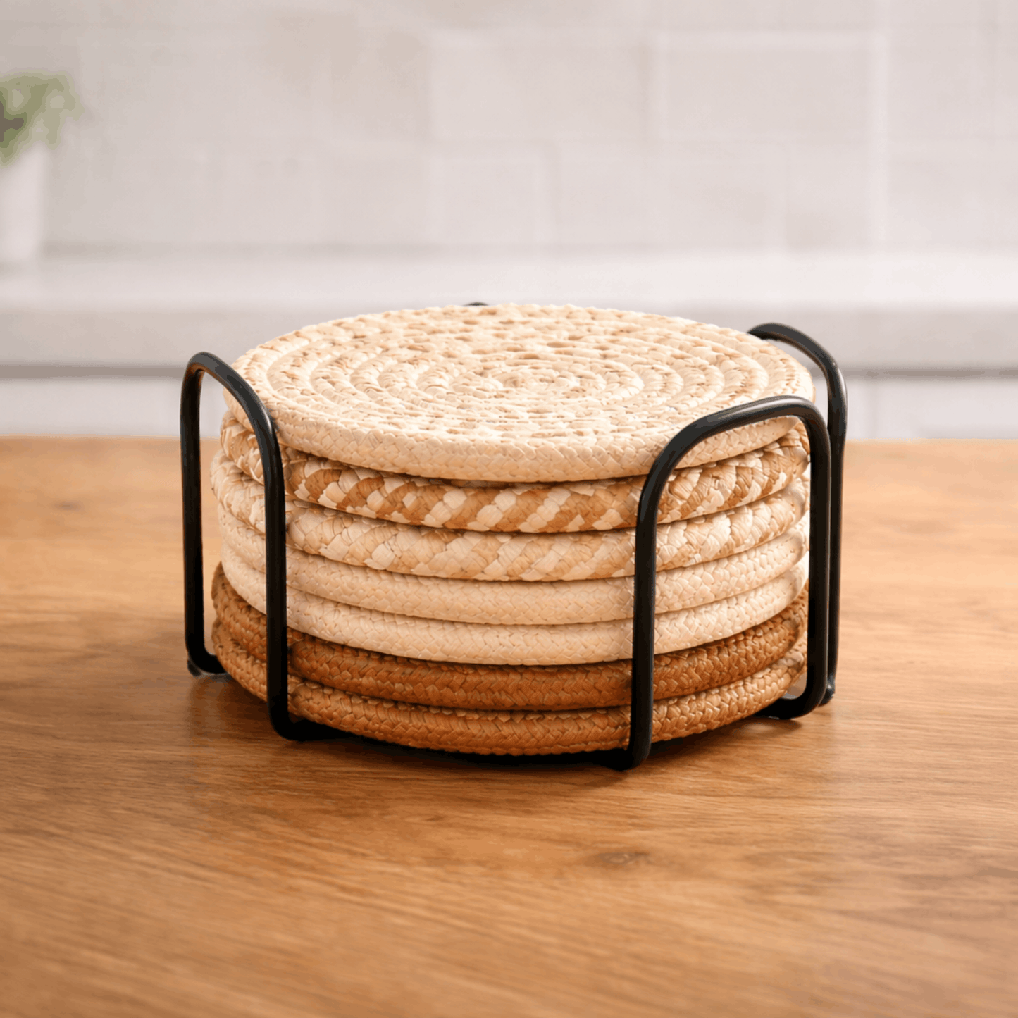 Set ronde gevlochten onderzetters voor glazen in verschillende beige en bruine tinten in een houder.