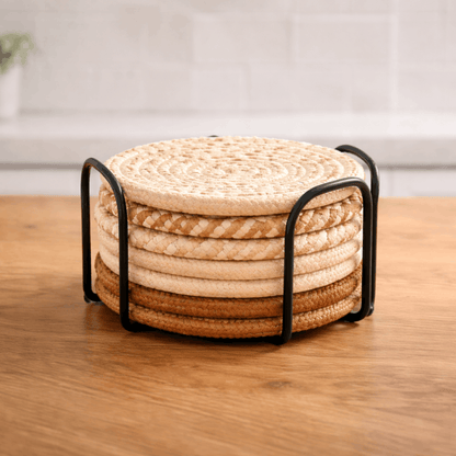 Set ronde gevlochten onderzetters voor glazen in verschillende beige en bruine tinten in een houder.