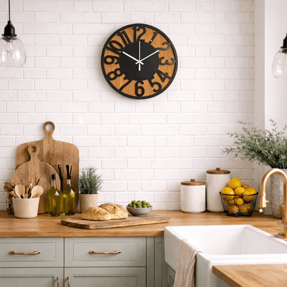 Ronde wandklok met houten achtergrond en zwarte cijfers, hangend aan een witte bakstenen muur in een keuken.