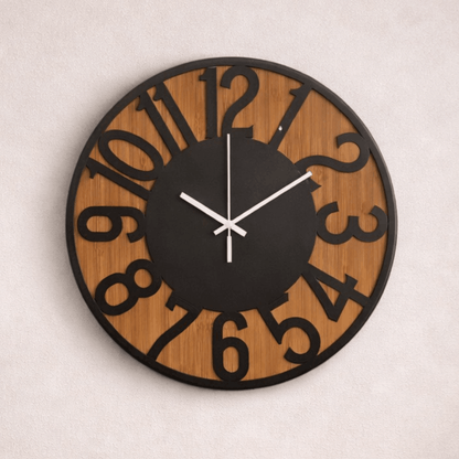 Ronde wandklok met houten achtergrond en zwarte cijfers, gemonteerd op een lichte muur.