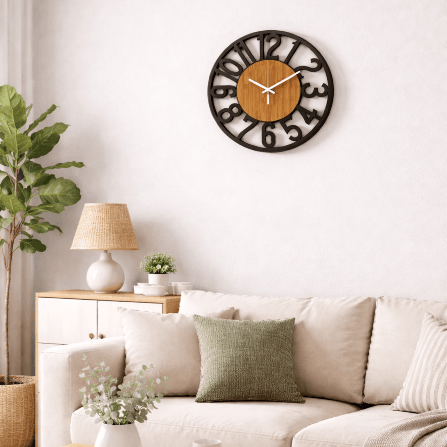 Wandklok met houten kern en uitgesneden zwarte cijfers, hangend boven een lichte bank in een woonkamer.