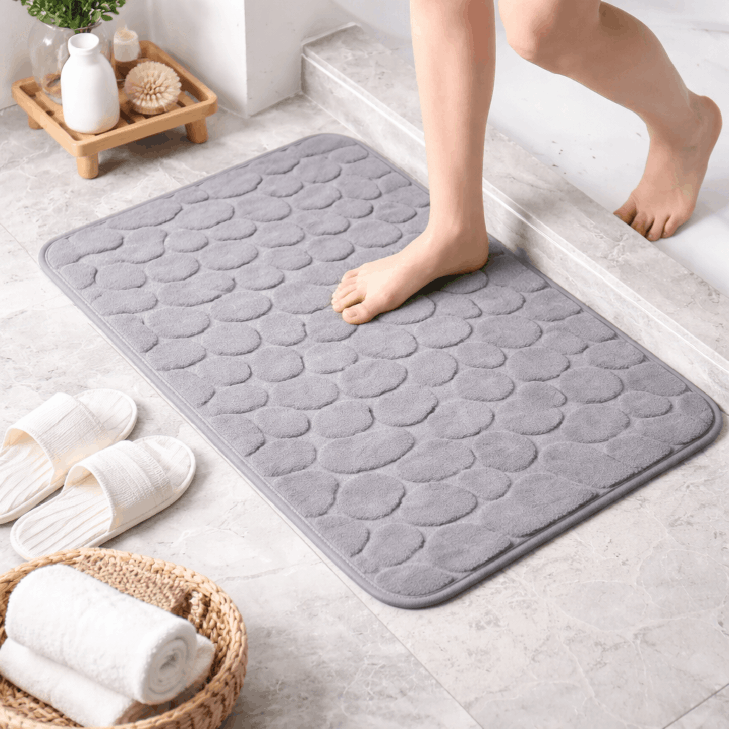 Zachte grijze badmat met steenstructuur en antislip onderkant, comfortabel om op te stappen na het douchen of baden.