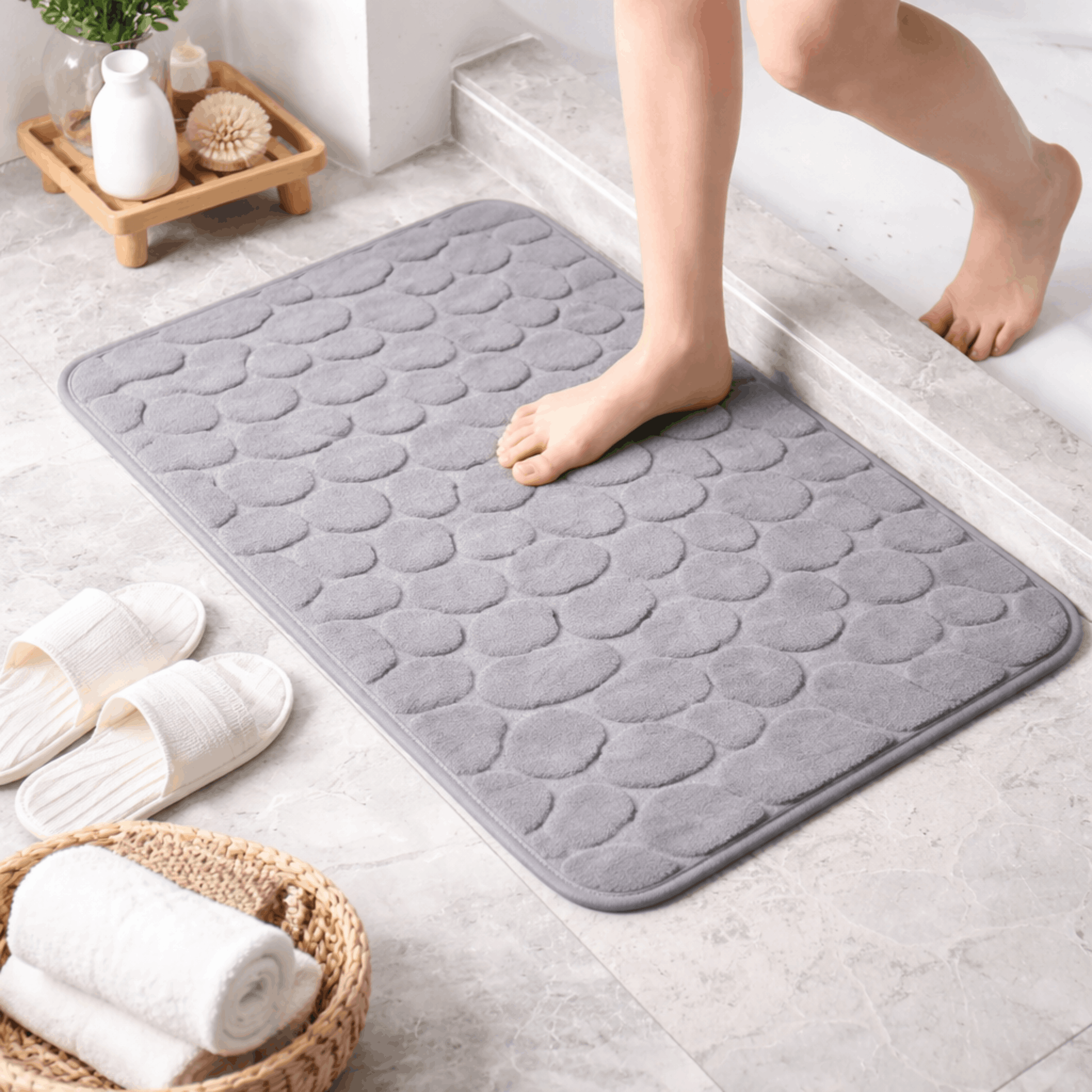 Zachte grijze badmat met steenstructuur en antislip onderkant, comfortabel om op te stappen na het douchen of baden.
