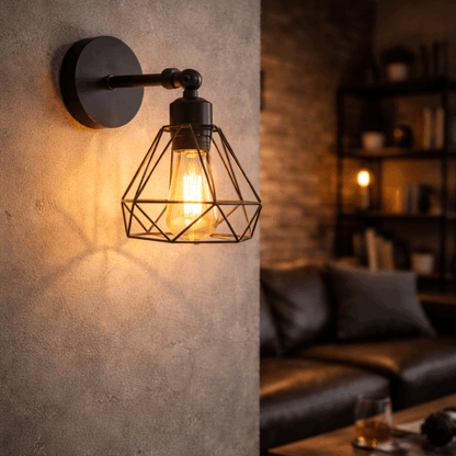 Zwarte industriële wandlamp met metalen kooi en warme lichtbron, gemonteerd aan de muur in een sfeervolle woonkamer.