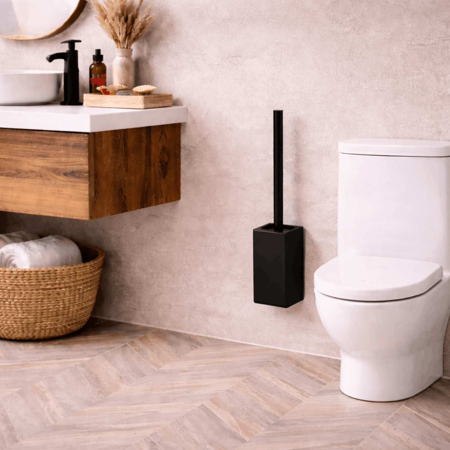 Zwarte wc borstel met rechthoekige houder, geplaatst naast een toilet in een moderne badkamer.