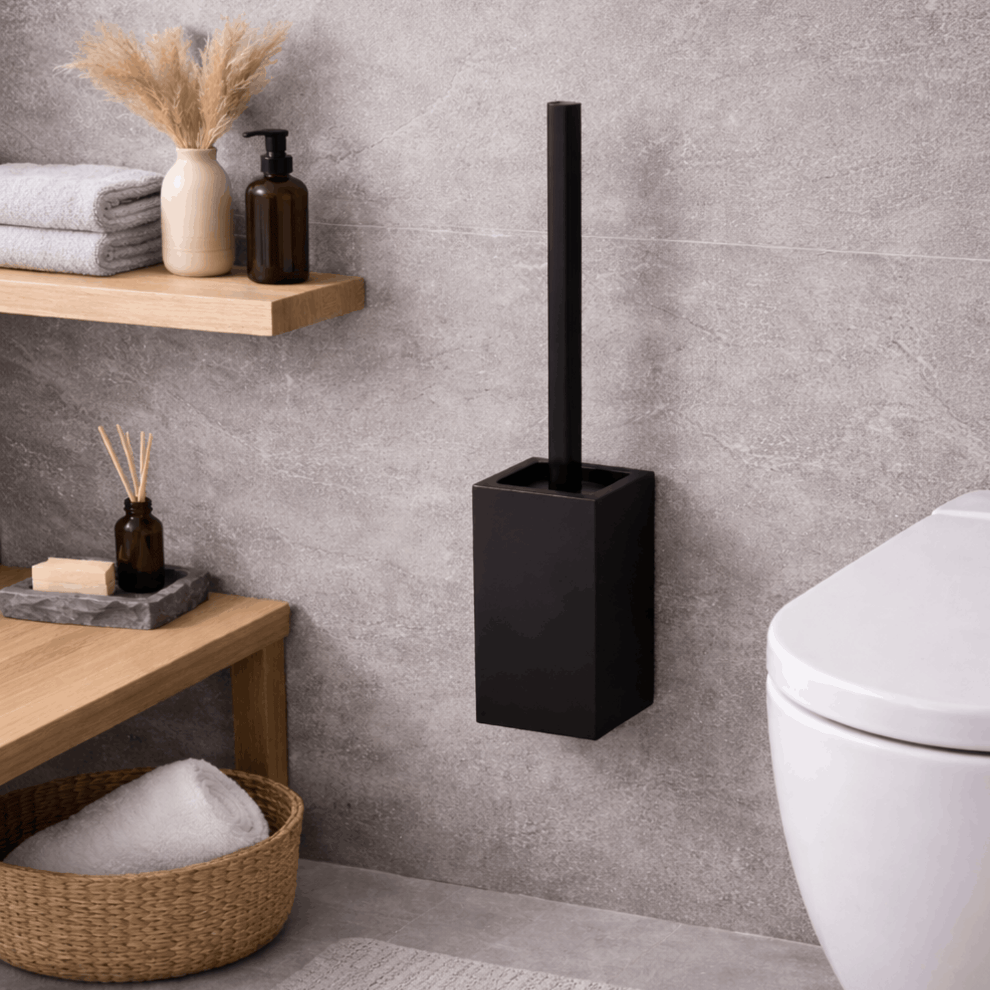 Moderne zwarte wc borstel met vierkante houder voor wandmontage, geplaatst naast een toilet in een stijlvolle badkamer.